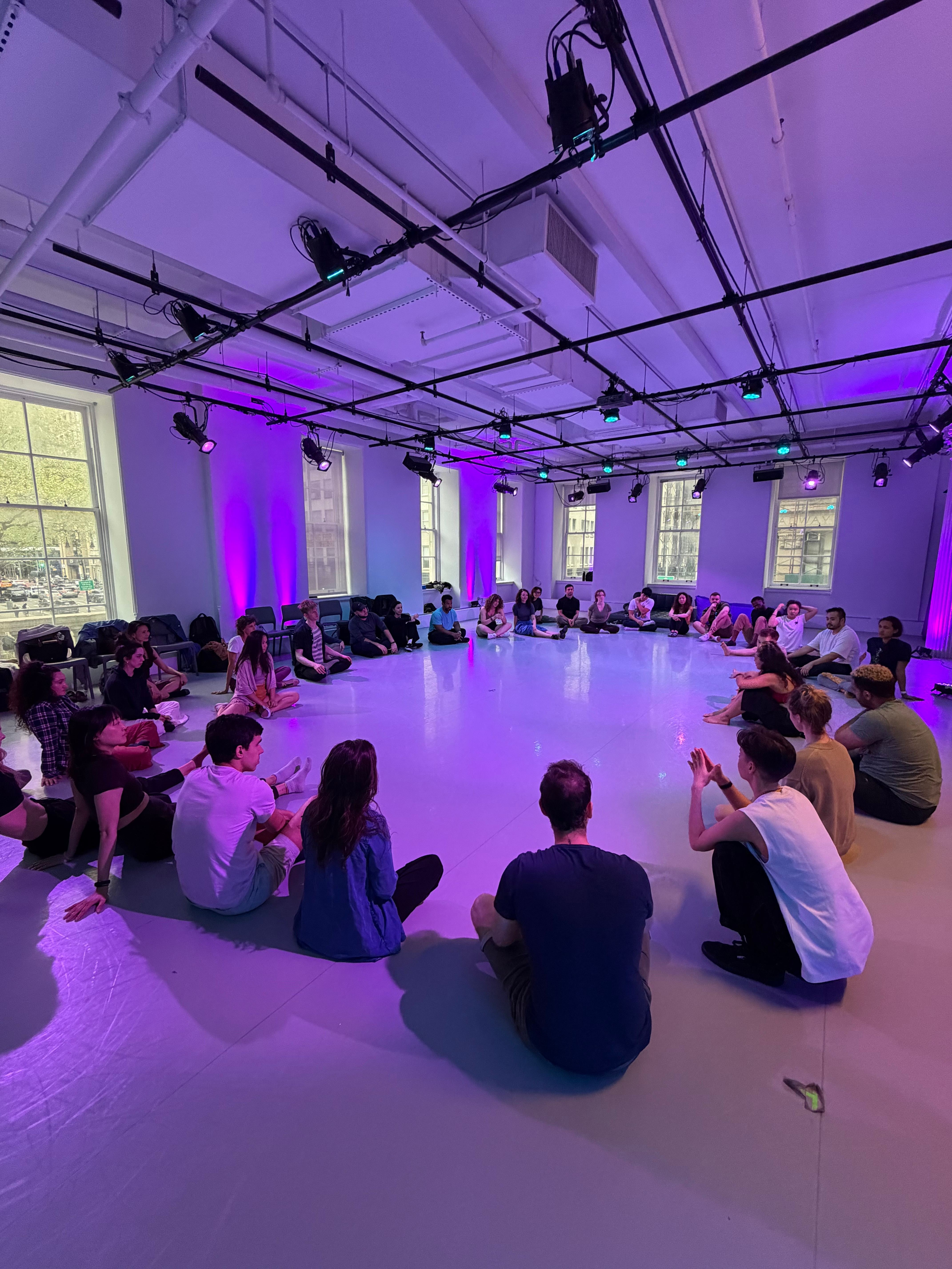 A zoukphoria dance class gathered in a purple-lit studio